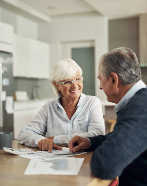 istock Retirement, life insurance and old couple with graphs and spreadsheet, pension plan paperwork and financial security. Savings, bills and budget, elderly woman and man at home with policy documents 1503301237