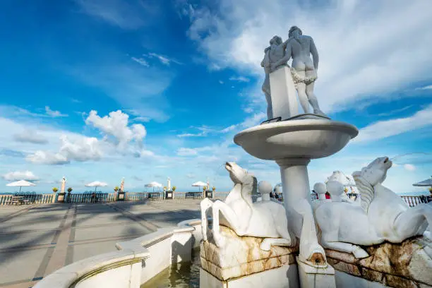 Representing the love between Leah and Teodorico.Rear viewn of the white marble structure,featurng horsessqurting water,aganst blue sky dotted with clouds.