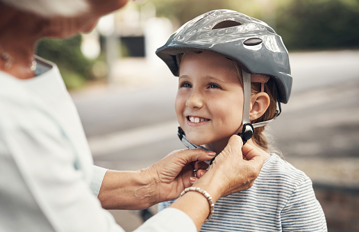 Helmet, safety and grandmother with child on bike in nature for bonding, learning and teaching. Happy, retirement and cycling with young girl and old woman in neighborhood park for family ride
