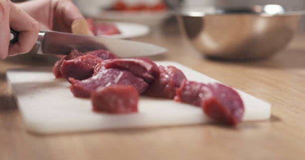 istock young female hand cutting raw beef with a knife on plastic board 1503304963