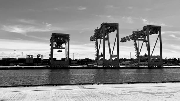 black and white photo of seaport boston massachusetts on a sunny day in june with big cranes for transportation of containers - 5461 imagens e fotografias de stock