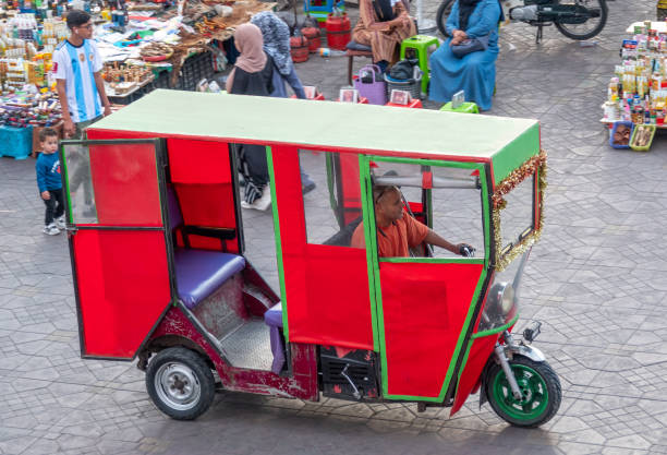 Auto Rickshaw at Djemma el Fna Square in Marrakesh, Morocco with people visible.