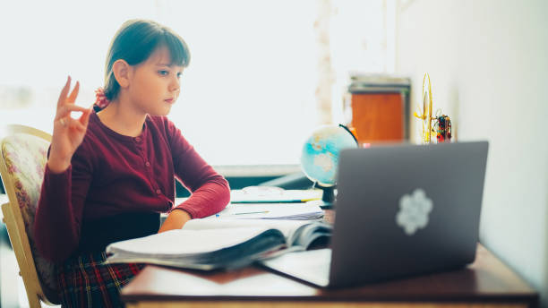 istock Girl e-learning at home is raising hand at online class 1503306953