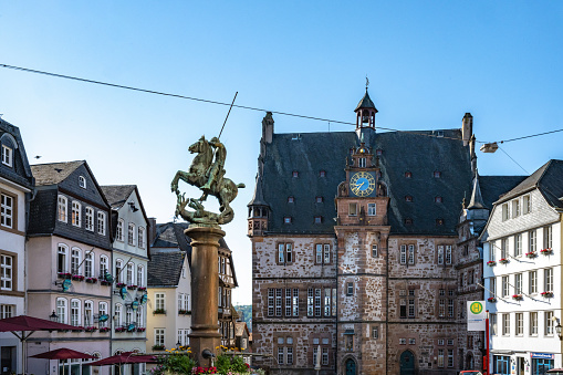 historic market place of Marburg with old town hall and fountain at morning hour in summer