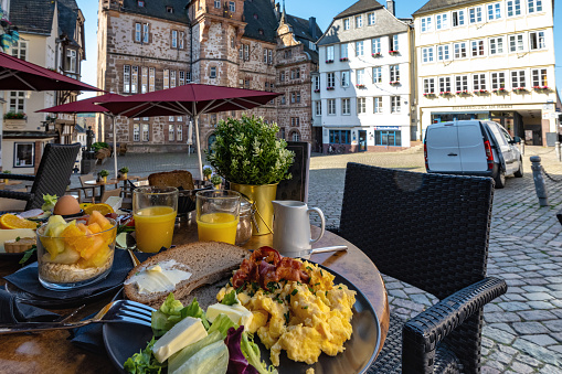 having breakfast at historic market place of Marburg at morning hour
