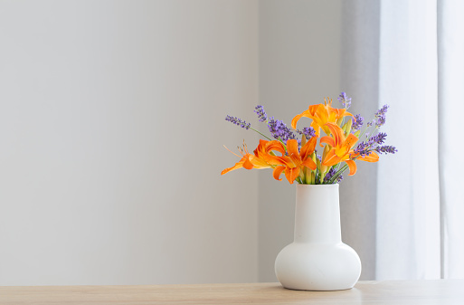 summer flowers in white jug on wooden shelf