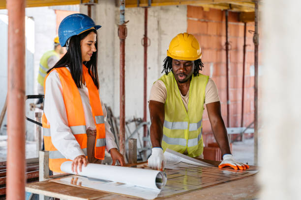 istock Female Engineer Showing The Blueprint To A Construction Worker On A Construction Site 1503311544