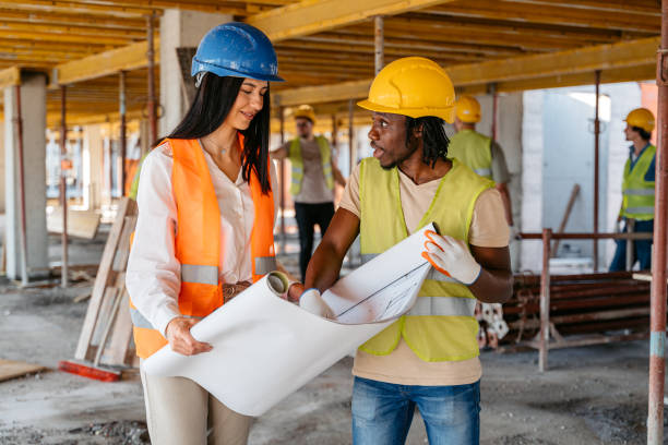istock Female Engineer Showing The Blueprint To A Construction Worker On A Construction Site 1503312288