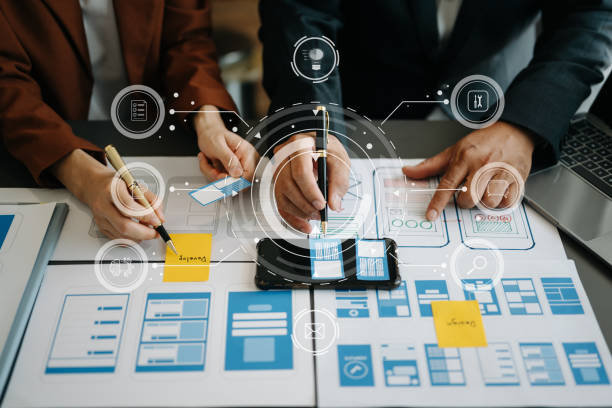 istock Close up view of UI developer team brainstorming on their project with laptop, smartphone and digital tablet. Creative digital development agency. with virtual icons 1503315542