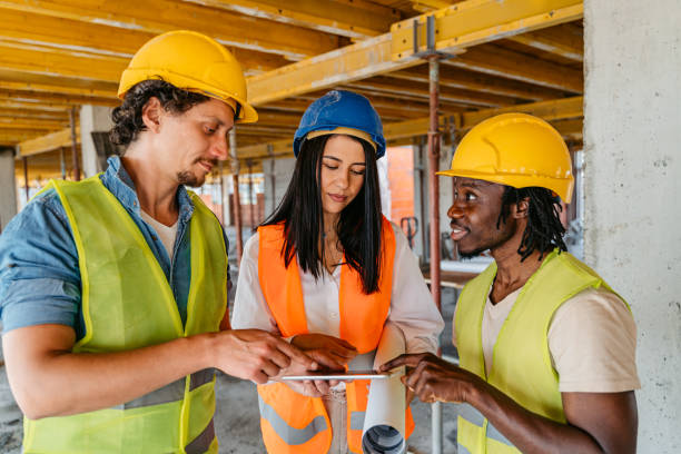 istock Female Engineer Showing The Blueprint On A Tablet To The Construction Workers On A Construction Site 1503316469