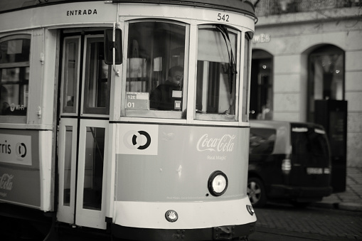 Lisbon, Portugal - Januay 15, 2023: An old fashioned tram runs along a street in Lisbon downtown.