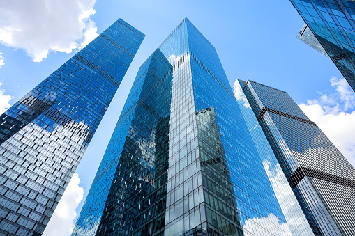 Modern glass silhouettes of skyscrapers in the city. Bottom view of modern skyscrapers in business district.