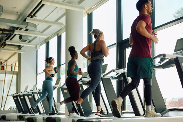 widok z tyłu wysportowanych ludzi biegających na bieżni na siłowni. - jogging running motivation group of people zdjęcia i obrazy z banku zdjęć