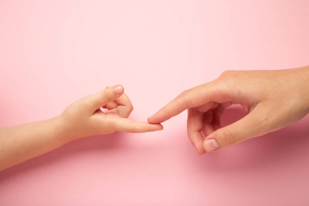istock Mother holding daughter hand on pink background. 1503324949