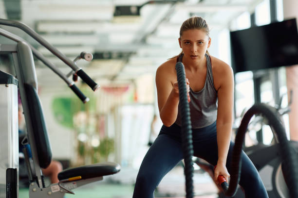 istock Determined sportswoman using battle ropes during cross training in a gym. 1503324954