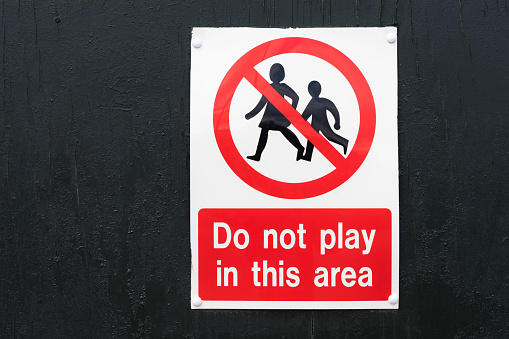 Close-up of a health and safety sign warning children not to play in the area.