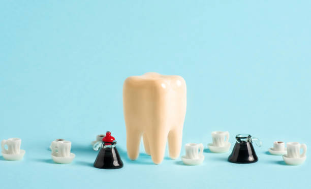 istock Yellow sick human tooth between coffee pots and coffee cups on blue background. Teeth staining with caffeinated beverages concept. Poster advertising dental clinic. 1503330863