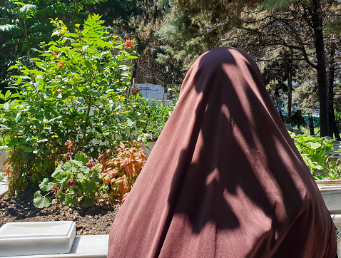 Muslim woman praying in cemetery