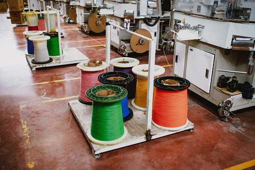 High speed braiding heavy machinery and steel cable processing equipments at the manufacturing of metal shielding braids for electrical cables plant in the factory warehouse. XXXL size taken with Canon 5D Mark4