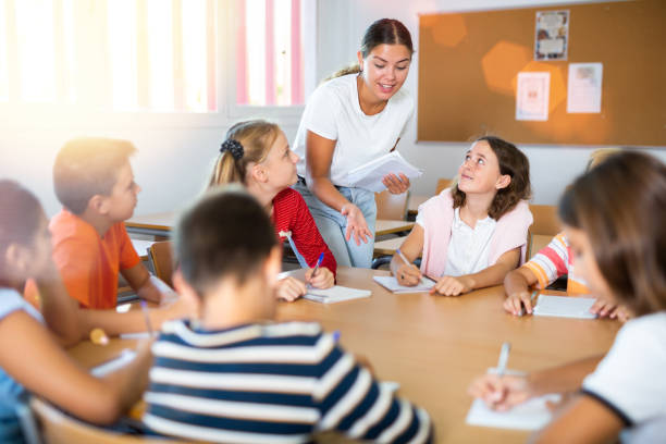 istock Kids sitting around desk in classroom and studying during lesson 1503343210