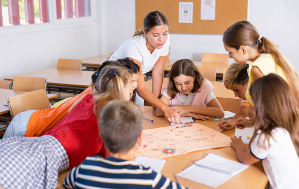 istock Schoolkids with teacher playing educational tabletop game in classroom 1503343255