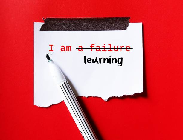 istock Torn paper stick on red wall with handwriting I AM A FAILURE, corrected to I AM LEARNING, to overcome negative self talk, replace with positive thoughts, with respect and self worth 1503344136