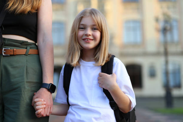 istock Smiling little girl first grader with a backpack holds her mother's hand. 1503346139