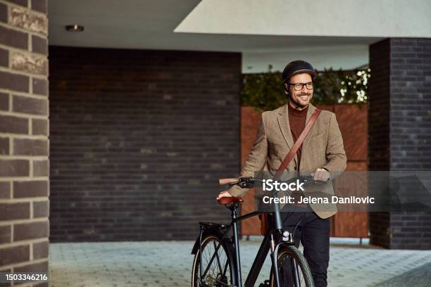 A Happy Businessman With A Helmet Walking On Foot With A Bicycle Outdoors Stock Photo - Download Image Now