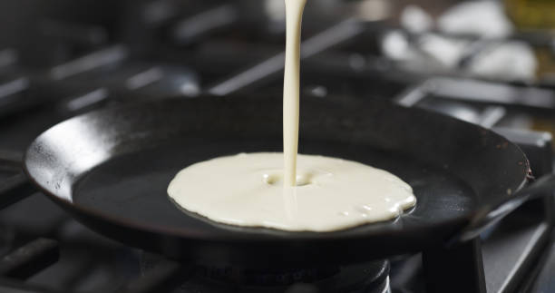 istock preparing blini or crepes batter pouring on hot pan 1503351915