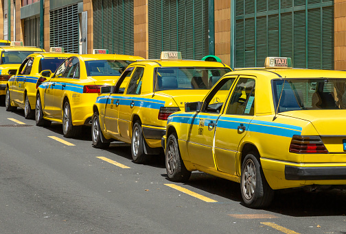 Madeira, Portugal - March 28, 2022: A row of yellow taxi cabs on the island of Funchal in Madeira, Portugal