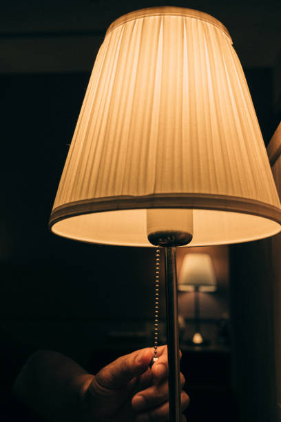 istock Image of a person's hand turning on a light in a dark room 1503357642