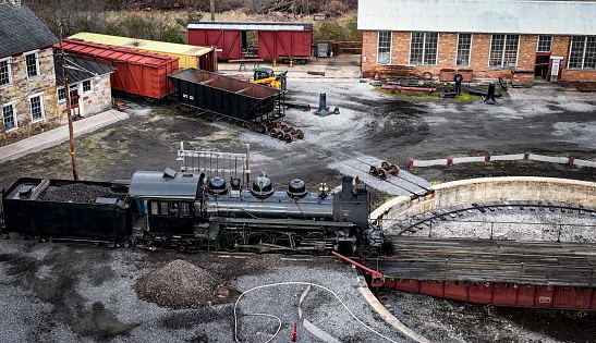 An Drone View of a Narrow Gauge Steam Locomotive Getting off a Turntable and Steaming Up for the Days Work on a Sunny Spring Day