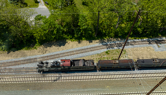 An Aerial View of a Steam Locomotive Moving Freight Cars Around in a Freight Yard to Organize a Freight Train on a Sunny Day