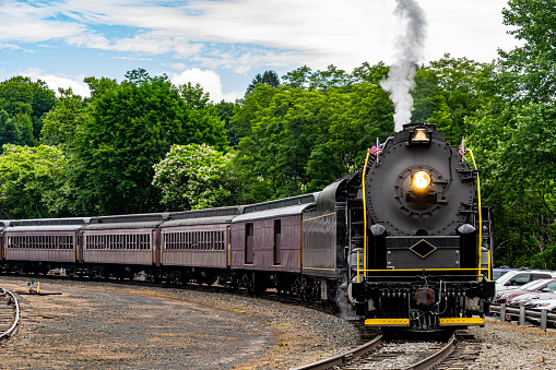 A View of A Restored Steam Passenger Train Approaching Around a Curve Traveling Thru Rural America on a Sunny Day
