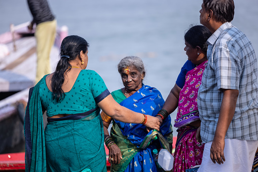 Varanasi, Uttar Pradesh, India - November 2022: Portrait of Unidentified south india woman tourists on ghats near river bank of ganges in varanasi to perform the rituals and worship lord shiva.