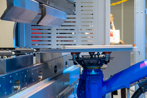 Close up the sheet metal bending process by robotic arm. The sheet metal working operation by autonomous system.