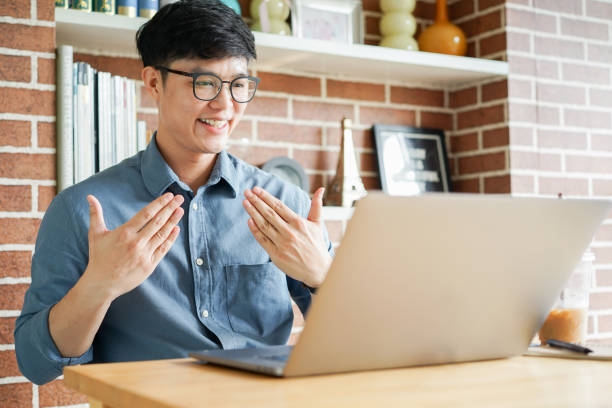 close up asian man make gesture hand about happy sign language to teaching or learning from webinar in home for lifestyle concept close up asian man make gesture hand about happy sign language to teaching or learning from webinar in home for lifestyle concept american sign language stock pictures, royalty-free photos & images