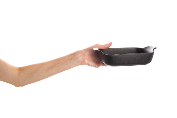 istock Black baking dish in hands isolated on white background 1503361084