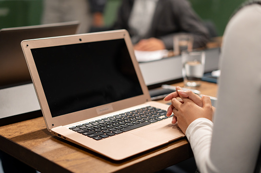 Close up of an Asian woman hand on her laptop during a meeting