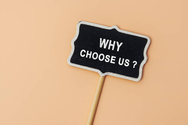 istock Why choose us - text on a small chalkboard on a beige background. Top view. Concept meaning list of advantages and disadvantages to select product or service 1503362001