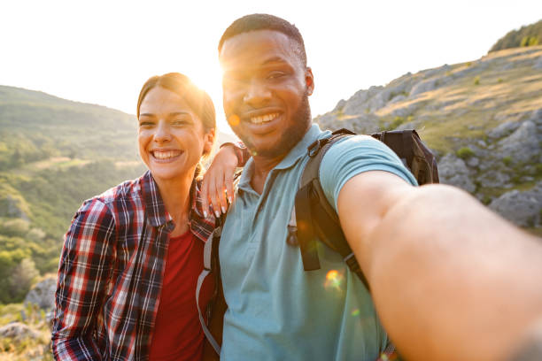 istock Young multiracial couple taking selfies on a mountain peak with wonderful view 1503363231