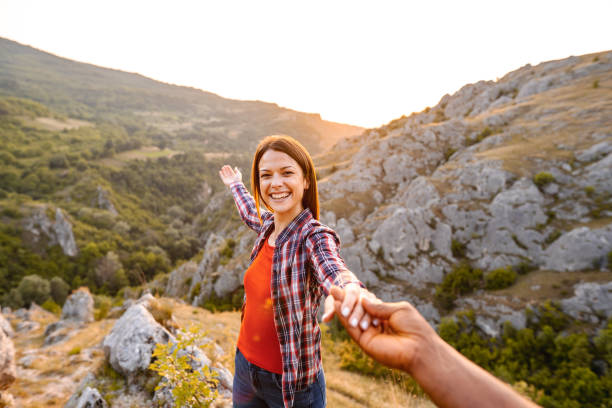 istock Happy multiracial couple holding hands while standing on mountain peak 1503364822