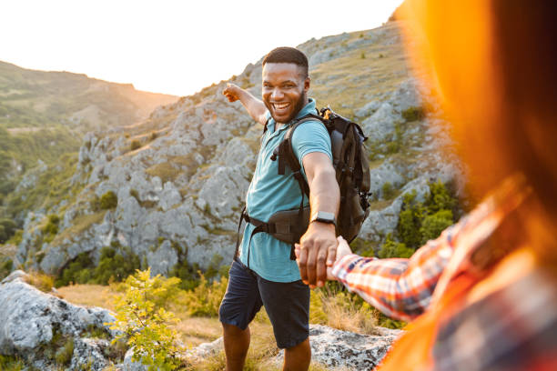 istock Happy multiracial couple holding hands while standing on mountain peak 1503364919
