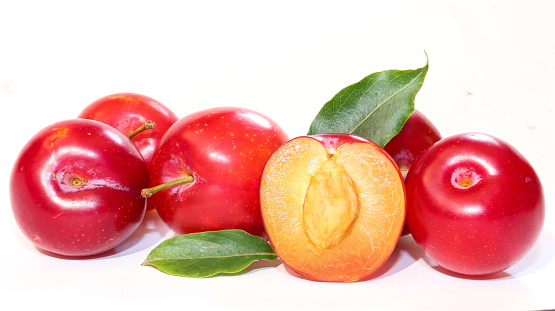 Ripe juicy red plums isolated on white background