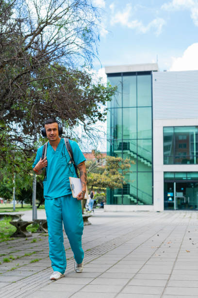 istock Nurse walks down the street while wearing his work uniform 1503369283