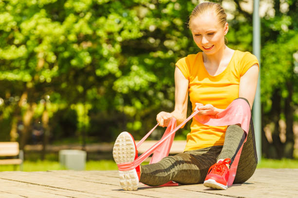 istock Girl doing exercise outdoor, using resistance fit band. 1503370677