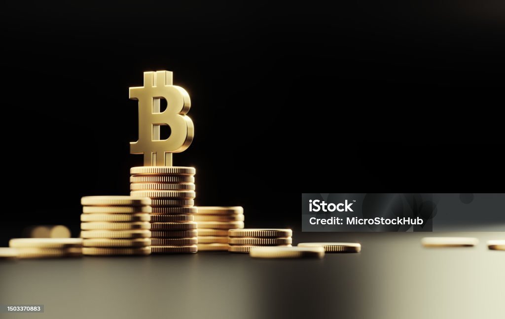 Gold Colored Bitcoin Symbol On Top Of Coin Stacks Before Black Background Gold colored Bitcoin symbol on top of coin stacks before black background. Horizontal composition with copy space. Backgrounds Stock Photo