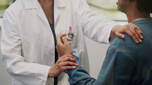 Doctor examines deaf patient's shoulder and arm