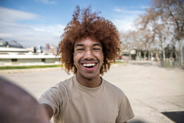 istock Young handsome guy smiling relaxed and looking at camera in the street taking a selfie. Confident happy man laughing and staring and holding the camera standing outdoors. 1503373055