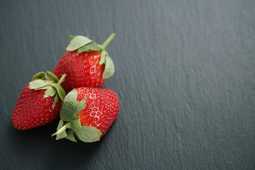 ripe organic strawberries on slate background, closeup